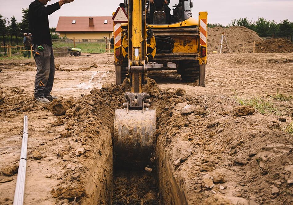 AdobeStock_507541082 Excavator at house construction site - digging foundations for modern house